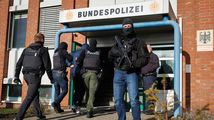 Einsatzkräfte der deutschen Polizei und der niederländischen Justiz führen einen Gefangenen in ein Gebäude der Bundespolizei. Fünf mutmaßliche Geldautomatensprenger sind von den Niederlanden nach Deutschland überstellt worden. 