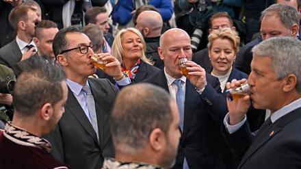 Cem Özdemir (Bündnis 90/Die Grünen, l), Bundesminister für Ernährung und Landwirtschaft, und Kai Wegner (CDU, 3.v.r), Regierender Bürgermeister von Berlin, trinken beim Eröffnungsrundgang über das Messegelände der Grünen Woche am Stand des Landes Marokko aus einem Glas. 