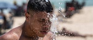 15. November 2023: Ein Mann nimmt an einem Strand von Rio de Janeiro eine Dusche.