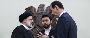 Bashar al-Assad (r), Präsident von Syrien, spricht mit Ebrahim Raisi (l), Präsident des Iran.