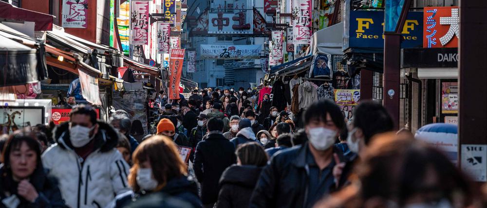 People walk past shops in the popular shopping area of Ueno in Tokyo on December 23, 2022. - Prices in Japan rose at their fastest pace since 1981 in November, data showed on December 23, fuelled in part by higher energy costs. (Photo by Richard A. Brooks / AFP)