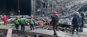 26.03.2024, Russland, Moskau: Auf diesem vom Pressedienst des russischen Katastrophenschutzministeriums veröffentlichten Foto arbeiten Rettungskräfte in der ausgebrannten Konzerthalle nach einem Terroranschlag auf das Gebäude der Crocus City Hall.
