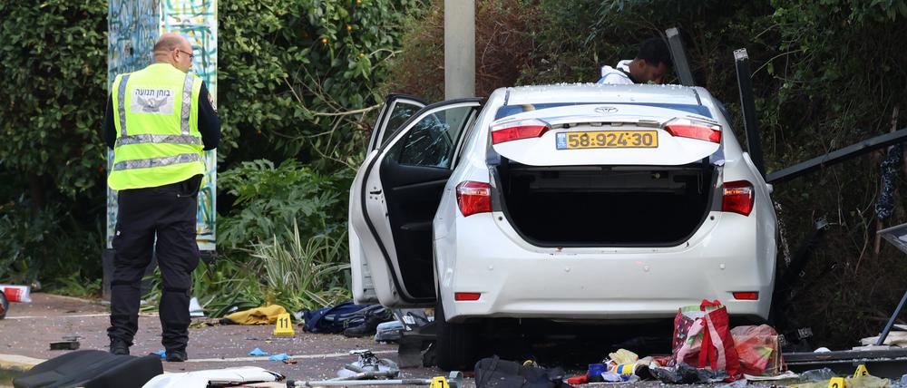 Israelische Rettungskräfte arbeiten neben einem beschädigten Auto nach einem Rammangriff in Ra’anana. 
