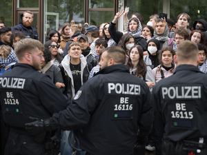 Demonstranten stehen während einer propalästinensischen Demonstration der Gruppe „Student Coalition Berlin“ auf dem Theaterhof der Freien Universität Berlin vor Polizeibeamten außerhalb des Camps. 