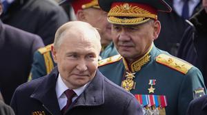 Wladimir Putin (l), Präsident von Russland, und Sergej Schoigu, Verteidigungsminister von Russland, verlassen den Roten Platz.
