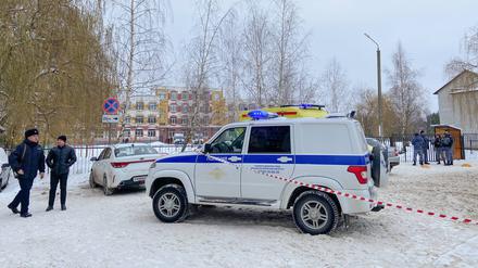 Einsatzkräfte stehen vor dem Gymnasium von Brjansk.