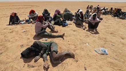 Migranten aus afrikanischen Ländern südlich der Sahara sitzen am 16. Juli 2023 in einem unbewohnten Gebiet nahe der libyschen Grenzstadt Al-Assah.