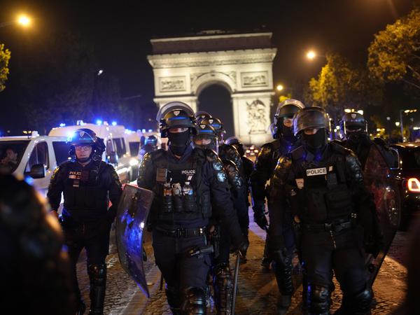 Polizisten patrouillieren vor dem Arc de Triomphe auf der Champs Elysees in Paris. 