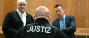 Ein Justizbeamter steht vor der Urteilsverkündung im Gerichtssaal im Landgericht Hannover vor den Anwälten der Angeklagten. 