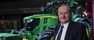Joachim Rukwied, Präsident des Deutschen Bauernverbandes steht vor der Eröffnung der Grünen Woche auf dem Erlebnis-Bauernhof vor einem Traktor.