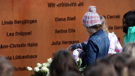 Schüler legen bei einer Gedenkfeier Rosen vor eine Gedenktafel mit den Namen der verstorbenen Opfer das Absturzes der Germanwings-Maschine (Archivbild). 