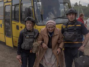 Eine evakuierte Frau kommt in einem Bus an einem Evakuierungspunkt in der Region Charkiw an.