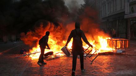 Randalierer stehen am 07.07.2017 im Schanzenviertel in Hamburg vor einer brennenden Barrikade.
