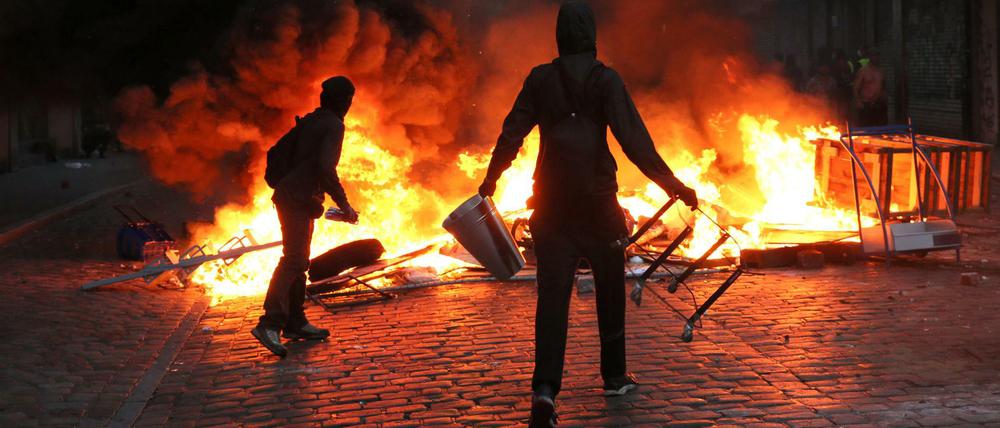 Randalierer stehen am 07.07.2017 im Schanzenviertel in Hamburg vor einer brennenden Barrikade.