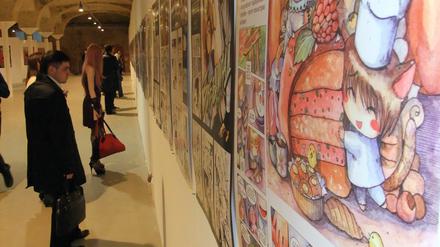 Manga in Moskau: Besucher betrachten Comic-Zeichnungen in der Ausstellung "KomMissija" im Künstlerzentrum Winsawod.