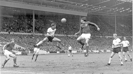 Martin Peters justs fails to get to a cross that is headed away by Wolfgang Weber. 