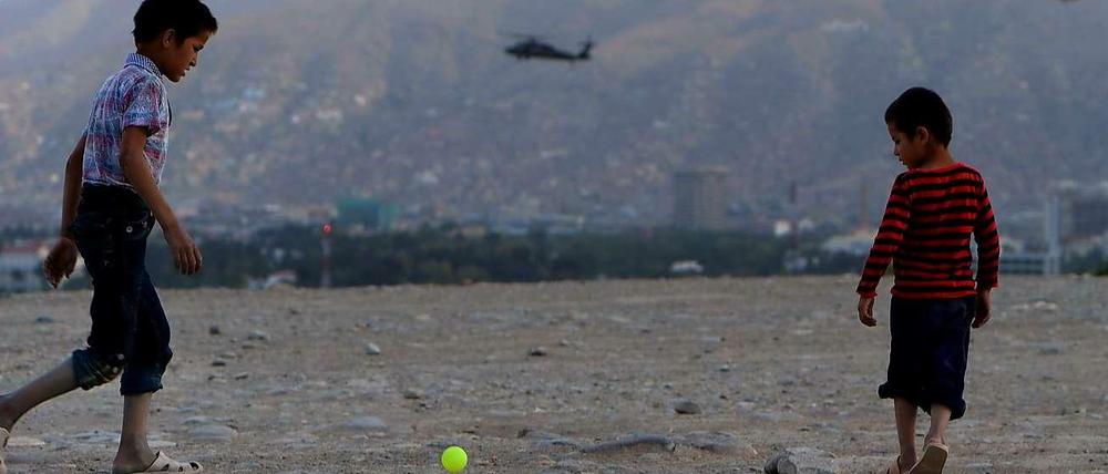 Im Schutz von Nato-Helikoptern. Afghanische Kinder Anfang August 2014 beim Ballspielen. Im Hintergrund die Bergspitze des Wazir Akbar Khan.