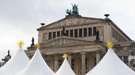 Es weihnachtet sehr auf dem Gendarmenmarkt. Die Zeltdächer vom Weihnachtsmarkt ragen vor dem Konzerthaus in den Himmel. 