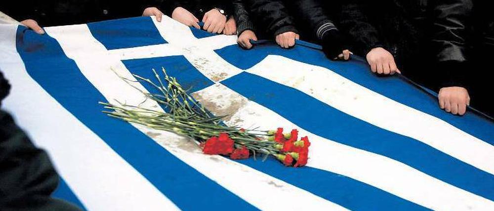 Nekrolog im November 2011. Studenten tragen in Athen die griechische Flagge zu Grabe. Foto: Alkis Konstantinidis, dpa