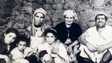 Gemeinsame Grabwache. Jüdische Familie und Berberfrau mit drei Kindern am Grab des Heiligen El Hens in Marrakesch. 