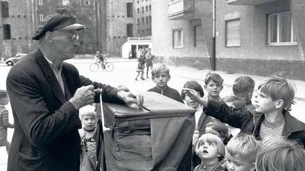 Melodie der Straße. Dieses Foto eines Leierkastenmanns, der 1958 Berliner Kinder unterhält, stammt aus dem „Berliner Liederbuch“. 