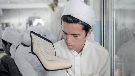 Ein malaysischer Koranschüler prägt sich zum Beginn des Ramadan Suren ein.