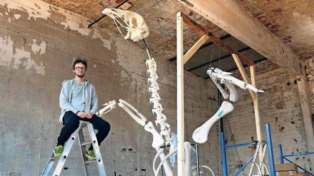 Andreas Greiner im Atelier vor dem vergrößerten Knochenmodell seines Masthahns Heinrich.