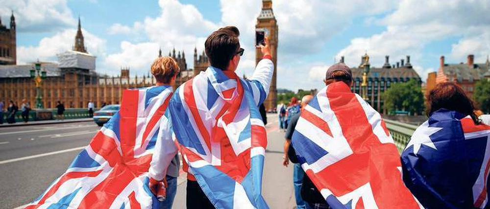 Dem Kontinent den Rücken. Junge Großbritannien-Enthusiasten spazieren über die Westminster Bridge in London. 