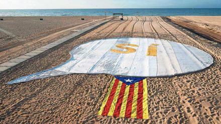 Zeichen setzen. Ein Ja zur Unabhängigkeit und eine katalanische Flagge auf einem Strand nahe Barcelona. 