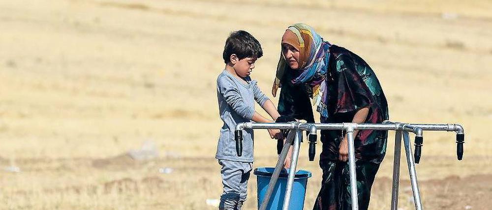 Zwei Flüchtlinge im Nordirak an einer Wasserstelle.
