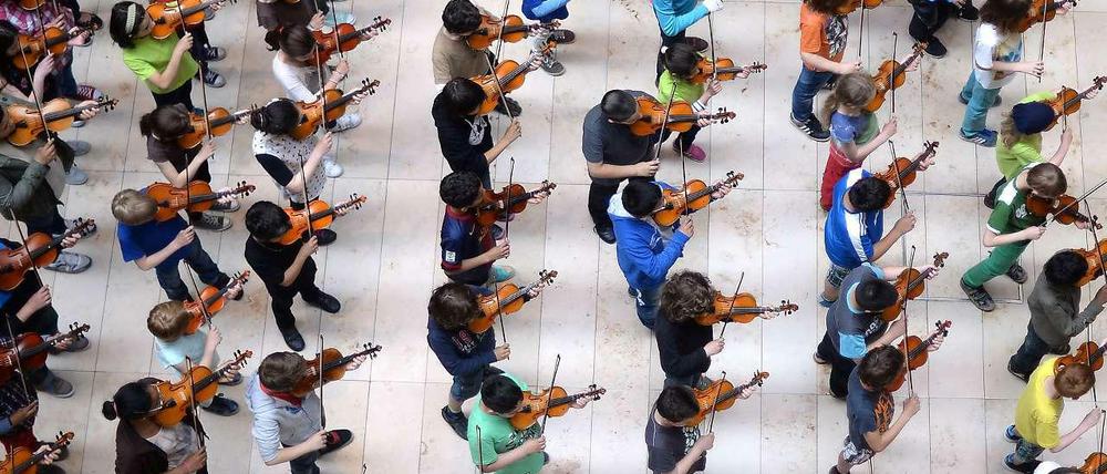 Kinder spielen Geige.