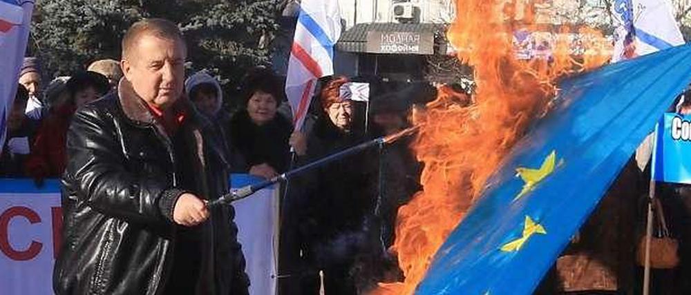 Eurasien statt Europa. Ein prorussischer Separatist verbrennt die EU-Flagge, im Dezember 2013 in Sewastopol auf der Krim.