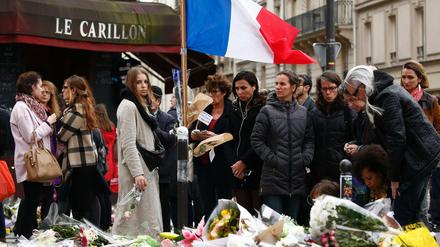 Trauernde versammeln sich vor den Restaurants "Le Petit Cambodge" and "Le Carillon" in Paris. 