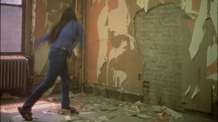Dara Friedman haut auf den Putz. Ein großformatiges Produktionsfoto aus dem Super-8-Film „Whip Whipping the Wall“ (1998–2002).