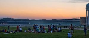 Junge Leute sitzen abends auf dem Tempelhofer Feld.