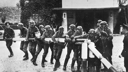 Beim Einmarsch deutscher Truppen in Polen am 1. September 1939 reißen Soldaten der deutschen Wehrmacht einen rot-weißen Schlagbaum an der deutsch-polnischen Grenze nieder. 
