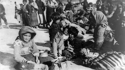 Eine Gruppe armenischer Flüchtlinge aus dem osmanischen Reich sitzt 1915 in Syrien auf dem Boden. Foto: Library of Congress/dpa