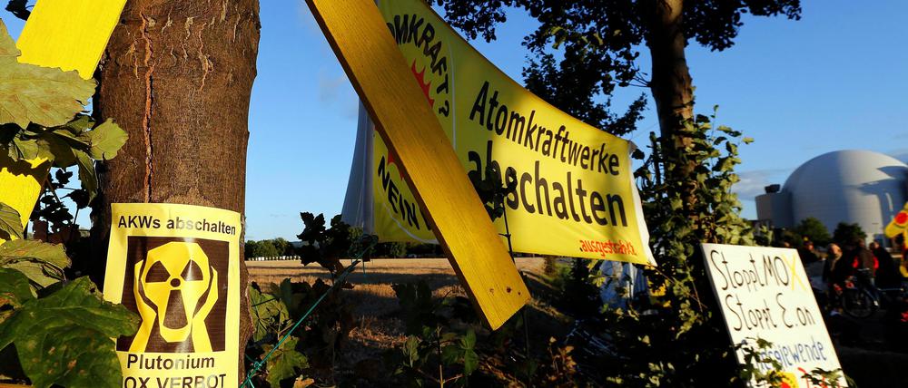 Ein Banner mit der Aufschrift "Atomkraftwerke abschalten" hängt zwischen Bäumen vor dem Atomkraftwerk Grohnde in Emmerthal.