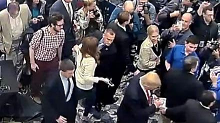 Rechts unten ist Donald Trump zu sehen, in der Mitte Corey Lewandowski, der Michelle Fields (in heller Kluft) am Arm fasst und abdrängt.