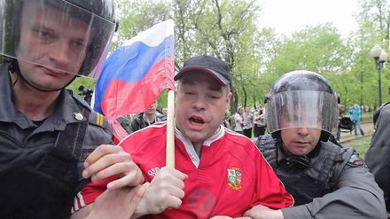 Bei einer Anti-Putin-Demo im Mai 2012 in Moskau wird ein Mann von zwei Polizisten festgenommen. Ein halbes Jahr nach den blutigen Unruhen gegen Kremlchef Wladimir Putin ist ein erster Teilnehmer zu viereinhalb Jahren Haftverurteilt worden. 