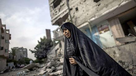 Eine Frau steht im nördlichen Gaza-Streifen vor einem Haus, das bei Luftschlägen beschädigt wurde.