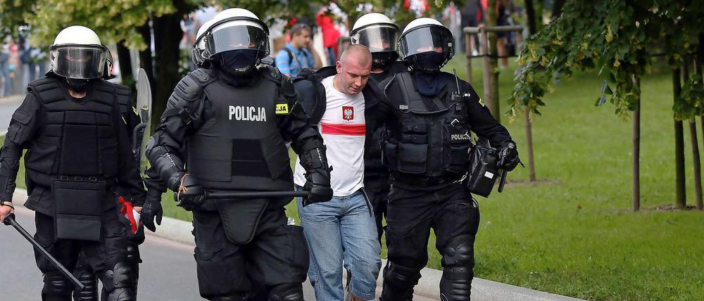 Festgesetzt. Polizeikräfte beim Einsatz gegen Hooligans. Am Abend nach dem Spiel Polen gegen Russland war es zu heftigen Ausschreitungen gekommen.