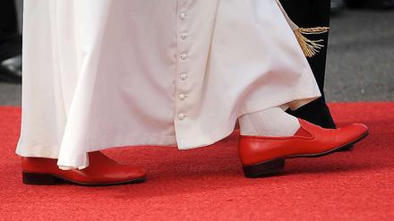 Auf roten Socken ist der Papst nicht unterwegs, wohl aber mit schicken roten Schlappen. 
