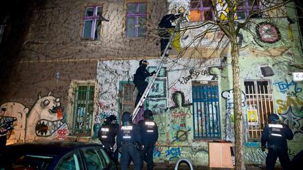 Polizisten steigen über eine Leiter in die Liebigstraße 34.