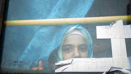 Ein syrisches Mädchen blickt aus einem Busfenster. Das Kind lebt schon seit Monaten in einem Flüchtlingslager an der syrisch-türkischen Grenze.