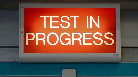 Ein rotes Schild mit der Aufschrift "Test in Progress"