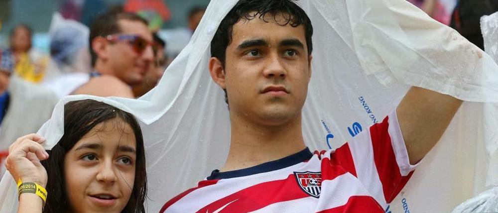 US-Fans schützen sich vor dem prasselnden Regen im Stadion. 