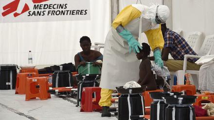 Ein Mitarbeiter der Organisation "Ärzte ohne Grenzen" untersucht in Liberia ein Mädchen auf Ebola. 