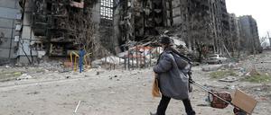 Eine Bewohnerin von Mariupol geht durch die zerstörten Straßen