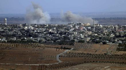 Blick von den israelisch besetzten Golan-Höhen auf die syrische Stadt Jubata al-Khashab, die von einem Hubschrauber der syrischen Regierungstruppen bombardiert wurde.